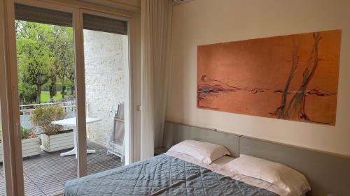 a bedroom with a bed and a large window at Hotel Luna in Sirmione