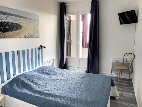 une chambre avec un lit bleu et une fenêtre dans l'établissement Appartement Familial Proche Plage et Forêt avec Parking Privé - FR-1-652-4, à Saint-Hilaire-de-Riez