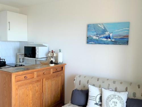 - un salon avec un comptoir et un four micro-ondes dans l'établissement Appartement bord de mer avec balcon, parking et commodités - FR-1-652-17, à Saint-Hilaire-de-Riez