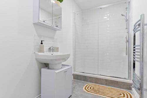 a white bathroom with a sink and a shower at Harwich Luxury Suite in Harwich