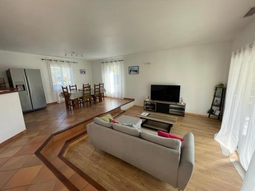 een woonkamer met een bank en een tv bij Charmante maison de 3 chambres - Proche de Montpellier in Prades-le-Lez