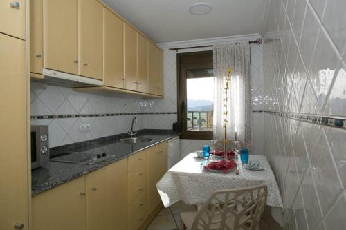 uma cozinha com uma mesa, um lavatório e uma janela em Casa Lola em Talarn