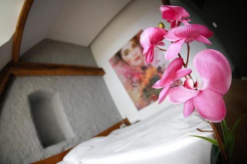 a bunch of pink flowers sitting on top of a bed at Appartement-Hotel GH Zum Goldenen Schiff in Enns