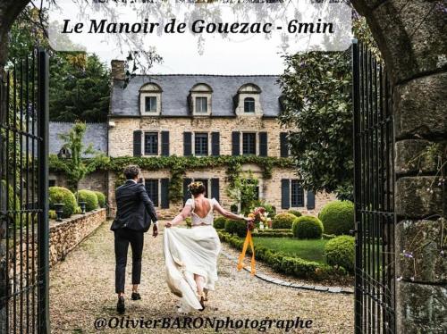 a bride and groom walking through the gate to a mansion at Le chalet Graines d'Amour in Grand-Champ