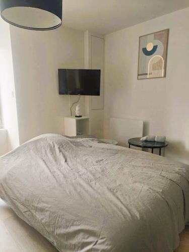 une chambre avec un lit et une télévision à écran plat dans l'établissement Maison de ville - wifi - checkin autonome, à Saint-Martin-sur-Oust