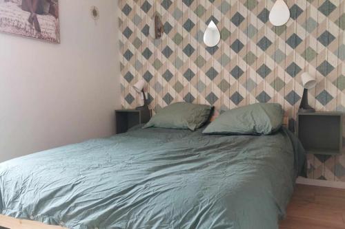 Una cama con dos almohadas encima en un dormitorio. en Maison de ville - wifi - checkin autonome, en Saint-Martin-sur-Oust