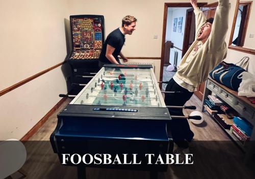 two men standing next to a foosball table at The Fortis House, Bournemouth, with Swimming Pool and Hot Tub Jacuzzi in Bournemouth