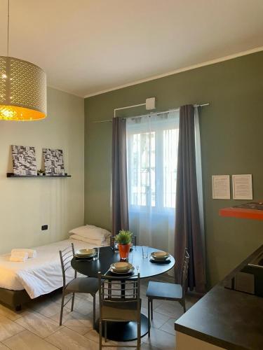 a room with a table and a bed and a table and chairs at Bnbook Residence La Red in Rho