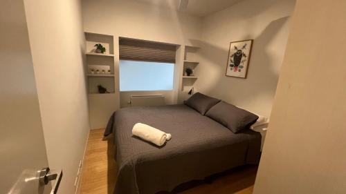 Habitación pequeña con cama y ventana en 2 Bedroom Apartment Eco Living at Nishi Canberra, en Canberra
