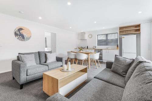 a living room with a couch and a table at Modern Retreat with King Bed - By KOSH BNB in Hamilton