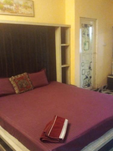 Una cama con colcha roja y una servilleta. en Hotel Raj Airport en kolkata