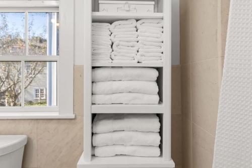 a stack of towels in a bathroom with a window at Circa 1789 Historic South End Downtown Home in Newburyport