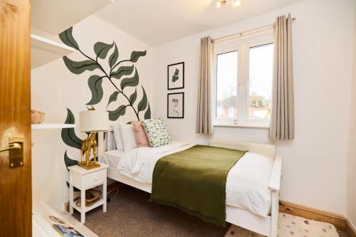 a bedroom with a bed with a plant mural on the wall at The Enfield Place - Elegant 4BDR House with Garden in Winchmore Hill