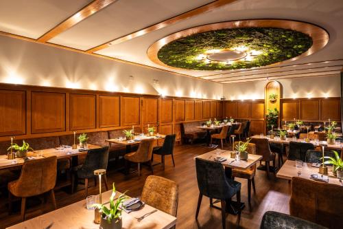 a restaurant with tables and chairs and a large ceiling at Uferdeck - Boutique Hotel in Traben-Trarbach