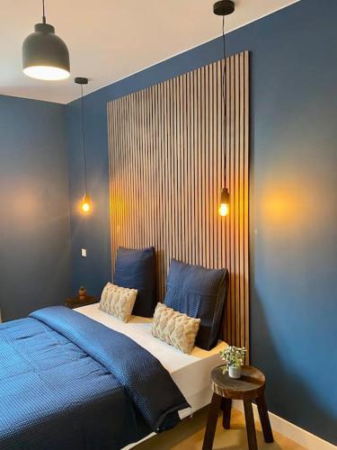 une chambre avec un lit et un mur bleu dans l'établissement ClassicBlue, centre de Mulhouse, à Mulhouse