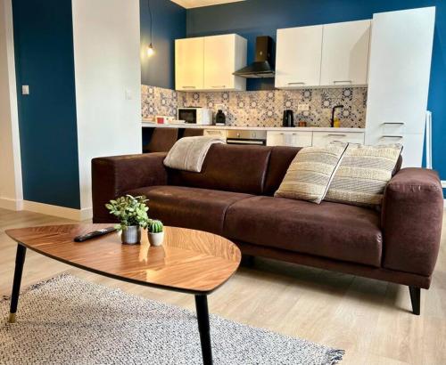 - un salon avec un canapé brun et une table basse dans l'établissement ClassicBlue, centre de Mulhouse, à Mulhouse