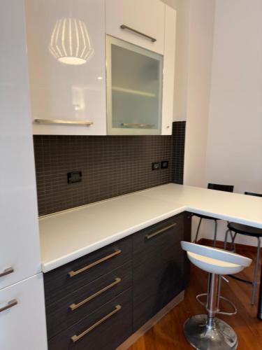 eine Küche mit einer weißen Theke und einem Stuhl in der Unterkunft Quarto Mare con giardino in Genua
