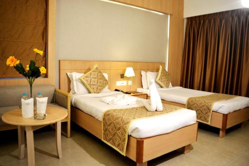 a hotel room with two beds and a table at HOTEL KRRISH in Patna