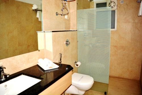 a bathroom with a toilet and a sink and a shower at HOTEL KRRISH in Patna
