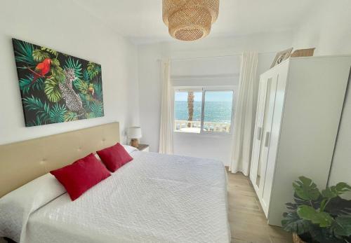 Un dormitorio con una cama con almohadas rojas y una ventana en Casa ADA, el balcón del mar, en Villaricos