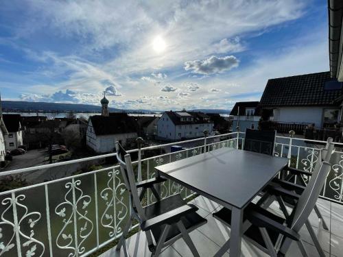 a table and chairs on a balcony with a view at Ferienwohnung Bodenseeblick in Allensbach