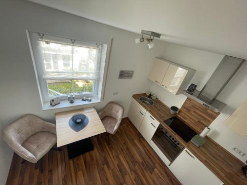 a small living room with a table and a kitchen at Melli‘s Seenahe Ferienwohnung in Langenargen