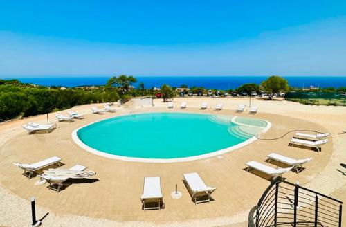 イーゾラ・ロッサにあるResidence with swimming-pool in Isola Rossa, just about 2 km from the beach La Marineddaのラウンジチェアとビーチ付きのスイミングプール