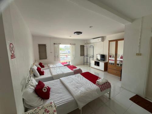a bedroom with two beds with red pillows at OYO 908 Sabai Place in Hua Hin