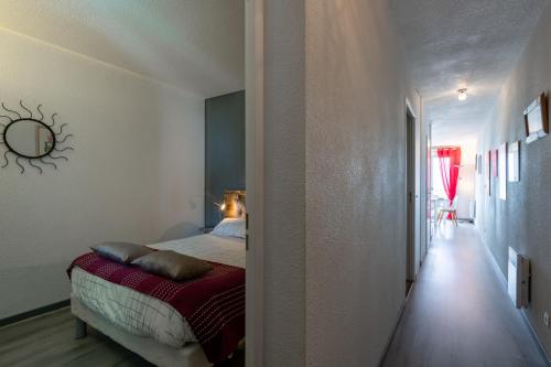 1 dormitorio con 1 cama con manta roja en Face à la Mer - Appt vue mer, en Mers-les-Bains