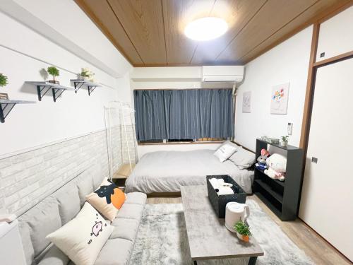mały pokój z łóżkiem i kanapą w obiekcie 高田馬場駅4分4人可303 w Tokio
