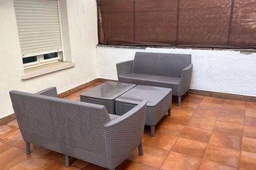 eine Terrasse mit 2 Stühlen, einem Tisch und einem Fenster in der Unterkunft Meta Habitat Ramon Lujan A in Madrid