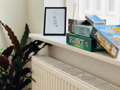 a shelf with books and a picture on it at Cozy Flats Silkeborg - 1MTH in Silkeborg