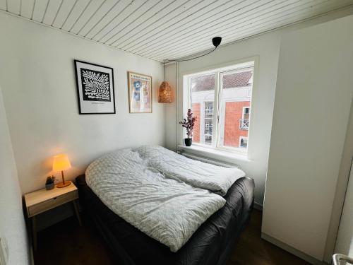 a small bedroom with a bed and a window at The Old Hotel Silkeborg - 1MTH in Silkeborg