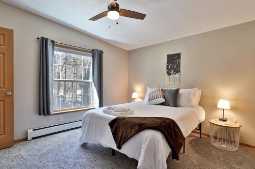 a bedroom with a bed with a ceiling fan and a window at Blueberry Hill Escape Pet Friendly HotTub Fire pit in Bridgewater