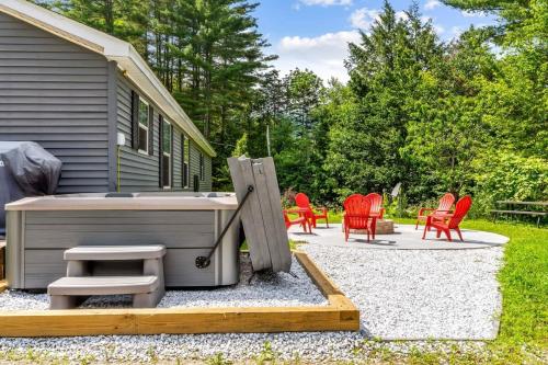 a patio with red chairs and a bench next to a house at Blueberry Hill Escape Pet Friendly HotTub Fire pit in Bridgewater