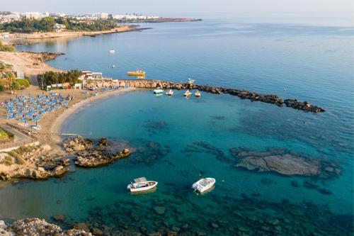 an aerial view of a beach with boats in the water at Cavo Maris Beach Hotel in Protaras