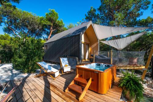 a tiny house with a hot tub on a deck at Arena One 99 Glamping in Pula