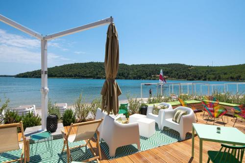 una terrazza con sedie, ombrellone e acqua di Arena One 99 Glamping a Pola (Pula)