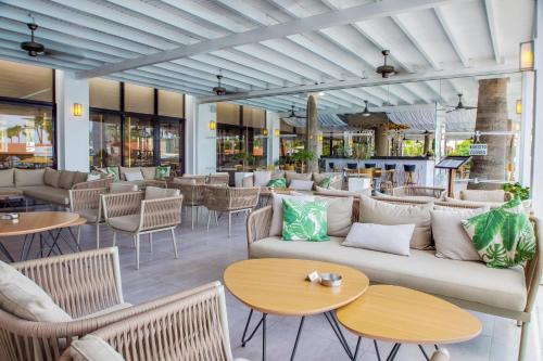 a lobby with a couch and tables and chairs at Cavo Maris Beach Hotel in Protaras
