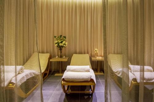 a hospital room with two beds and a vase of flowers at Cavo Maris Beach Hotel in Protaras