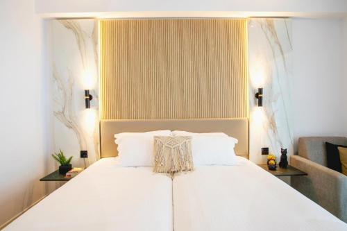 a bedroom with a white bed with white pillows at Cavo Maris Beach Hotel in Protaras