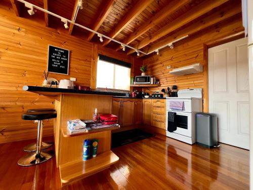 uma cozinha com paredes e pisos em madeira e um balcão em House with bay views - St Helens family escape em St Helens