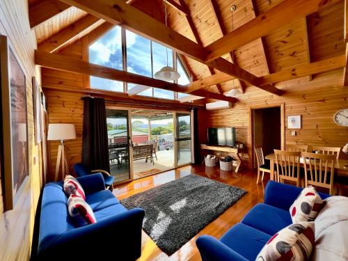ein Wohnzimmer mit blauen Sofas und ein Esszimmer in der Unterkunft House with bay views - St Helens family escape in St Helens