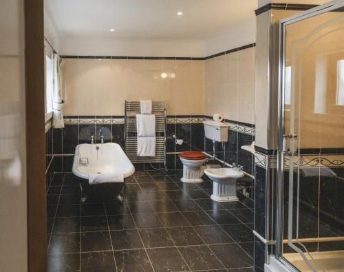a bathroom with a tub and a sink and a toilet at Lochgreen House Hotel & Spa in Loans