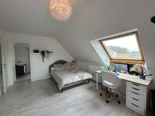 a bedroom with a bed and a desk and a window at Maison privative 6 chambres in Champhol