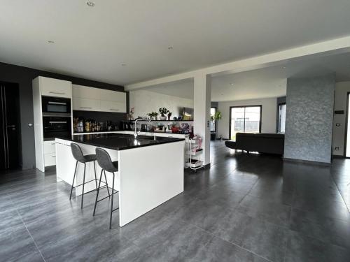 a kitchen and living room with a counter and chairs at Maison privative 6 chambres in Champhol