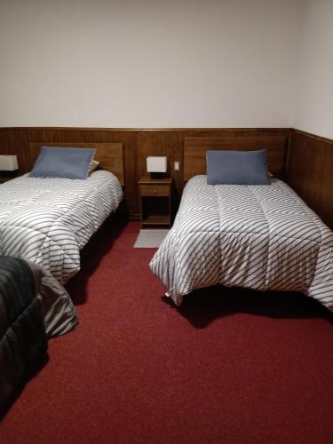 two beds sitting next to each other in a room at HOTEL ESTRECHÓ DE MAGALLANES in Punta Arenas