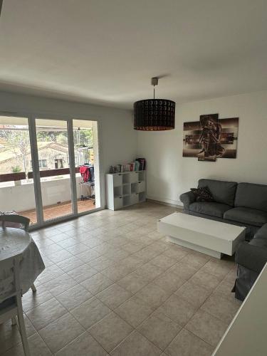 a living room with a couch and a table at Appartement Spacieux proche des Plages de la coudouliere in Six-Fours-les-Plages