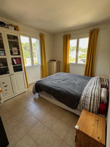 a bedroom with a bed and two windows at Appartement Spacieux proche des Plages de la coudouliere in Six-Fours-les-Plages