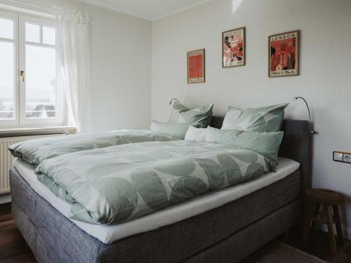 1 cama grande en un dormitorio con ventana en Ferienwohnung Bodenseeblick, en Allensbach